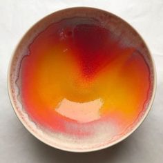 an orange and yellow bowl on a white surface