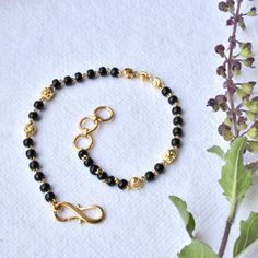 "Single strand gold chain bracelet with black beads and gold balls, handcrafted with love and care, this comfortable bracelet is a perfect accessory for everyday wear. Lightweight and stylish..! * Length : 5.5\" to 9\" + 0.5\" extender eg : 6\" length will fit wrist size of 6\"- 6.5\" * Gold : 18k Solid Yellow Gold * Gold Weight - 2.5 gms approx for 5.5\" inches with extender - For longer/shorter length, please ask for a quote before placing the order. If you like this bracelet, please press \"P Black Bracelet With Gold Beads, Gold Rosary Bracelet With Black Beads As Gift, Gold Spiritual Beaded Chain Bracelet, Traditional Black Beaded Bracelets With Tiny Beads, Traditional Gold Bracelet With Black Beads, Traditional Gold Beaded Bracelet With Black Beads, Traditional Gold Beaded Chain Bracelets, Gold Onyx Beaded Bracelets With Black Beads, Traditional Gold Bracelets With Black Beads