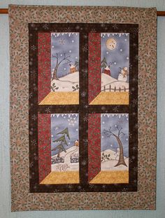 a quilted wall hanging on the side of a building with snowmen and trees