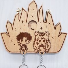 two wooden key chains with cartoon characters on them