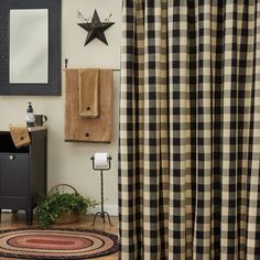 a black and white checkered shower curtain next to a rug with a star on it