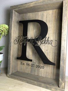 a wooden framed sign with the letter r on it