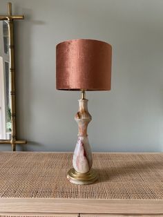 a table lamp with a pink shade on it