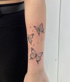 a woman's arm with three butterfly tattoos on the back of her left arm