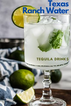 a tall glass filled with tequila water and limes