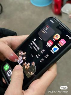 a person holding an iphone in their hand with various app icons on the display screen