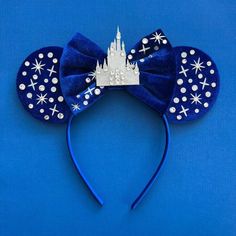 a blue mouse ears with a castle on top and snowflakes all over it