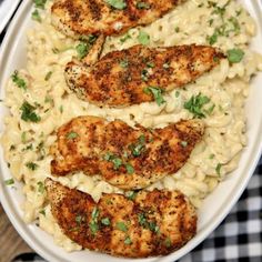 chicken with macaroni and cheese in a white bowl on a checkered table cloth