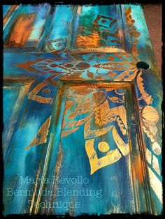 an artistic painting on the side of a building with gold and blue designs in it