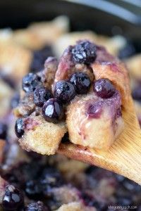 a wooden spoon filled with blueberries and crumbs