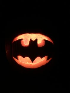 a carved pumpkin with a batman symbol on it