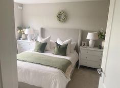 a white bed sitting in a bedroom next to two lamps on either side of it