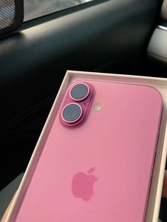 an apple phone in a pink box on a car seat with the lid open and two buttons showing