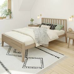 a bed sitting on top of a wooden floor next to a white and black rug