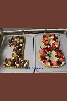 two cakes in the shape of the number six are decorated with strawberries, chocolates and marshmallows