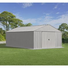 a large metal shed sitting on top of a lush green field