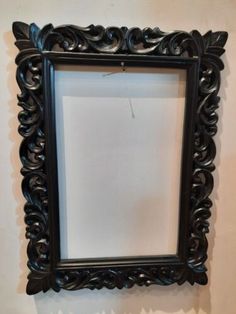 an ornate black frame hanging on the wall