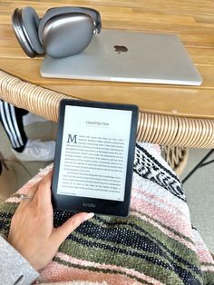 a person sitting at a table with an ipad and headphones on top of it