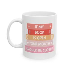 a coffee mug with the words if my book is open, your mouth should be closed