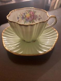 an antique tea cup and saucer on a table