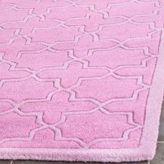 a pink rug with white lines on the top and bottom, in front of a tile floor