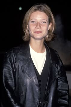 a woman wearing a black leather jacket and smiling