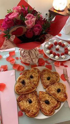 valentine's day desserts are arranged on a table with pink and red flowers