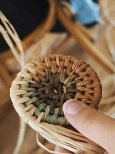 a person holding a woven object in their hand