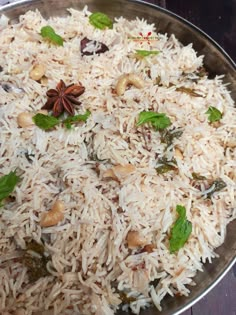 a silver bowl filled with rice and nuts