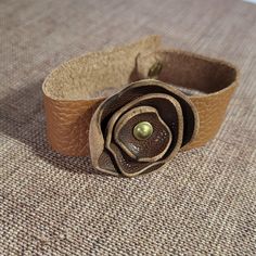 a close up of a leather flower on a carpet