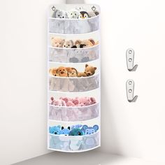 an over the door storage rack with stuffed animals in it and two hooks on each side