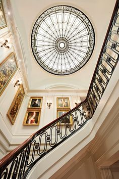 an ornate staircase in a building with paintings on the walls