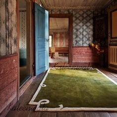 an open door leading into a room with green rugs on the floor and walls