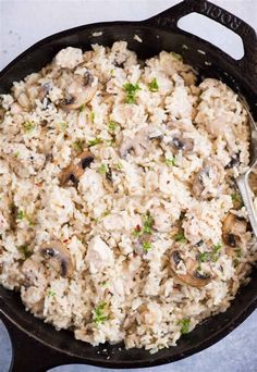 a skillet filled with rice and mushrooms