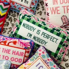 cross stitched pillows with sayings on them