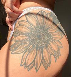 a woman's back with a sunflower tattoo on her lower half and bottom part