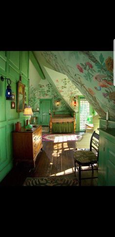 an attic bedroom with green walls and floral wallpaper on the ceiling, along with wooden furniture