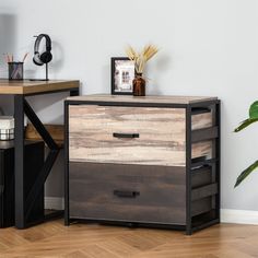 a wooden table with two drawers and a plant on it next to a white wall