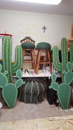 cactus decorations in the corner of a room with stools and other items on the floor