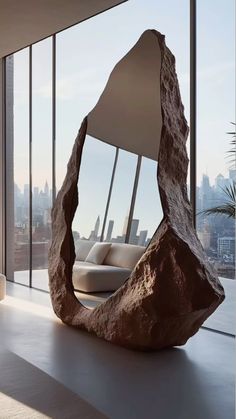 a large rock sitting on top of a white floor next to a tall glass window