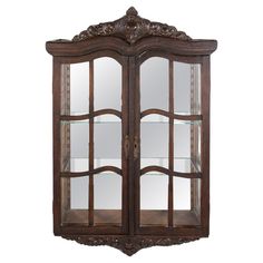 an ornate display cabinet with glass doors and carvings on the front, in dark wood