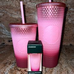 two pink tumblers with matching lids and straws