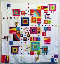 a white wall hanging with colorful squares and rectangles on it's sides