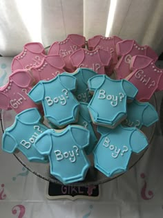 some cookies that are shaped like baby ones on a plate with pink and blue frosting