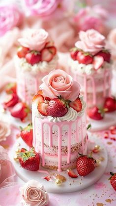 there are three cakes with strawberries on the top and one has pink icing