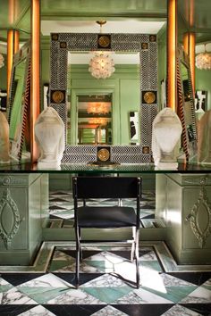 a room with a mirror, chair and chandelier