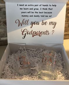 two mason jars in a gift box with congratulations written on the lids and bottom, which reads will you be my godparents?