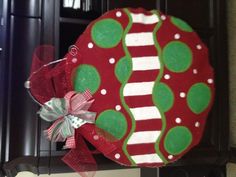 a red and green christmas ornament hanging on a dresser