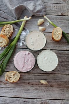 three different types of dips and bread on a wooden table