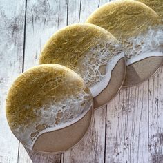 three cookies with white icing and brown sugar on wooden table next to each other